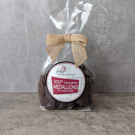Packaged chocolate medallions with a label on a gray background