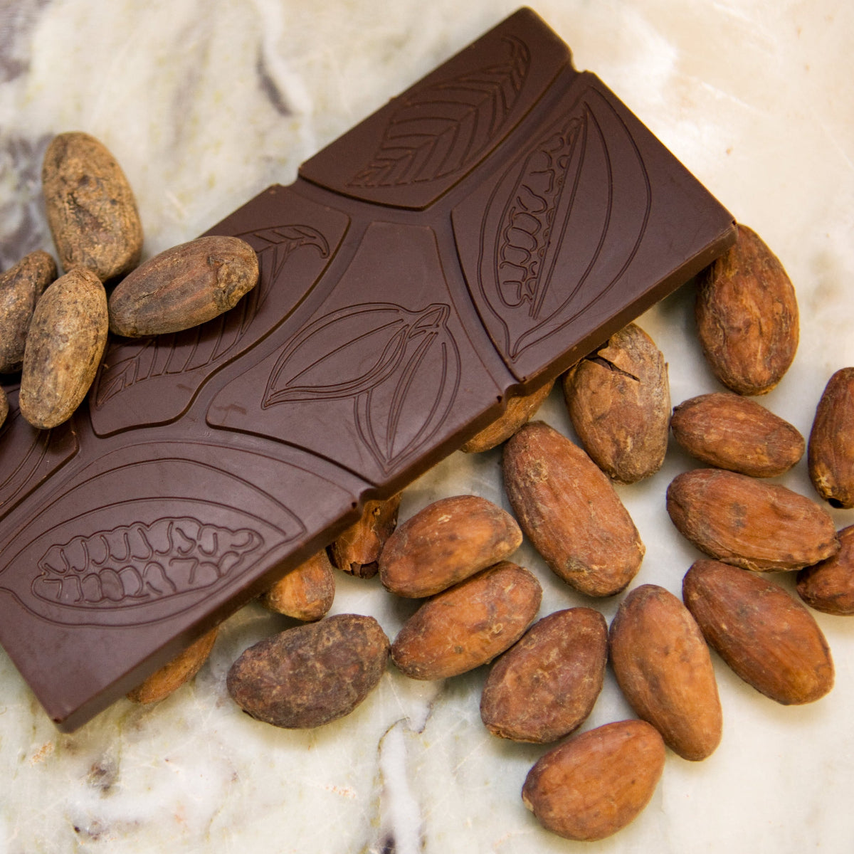Chocolate bar with cacao beans on a marble surface