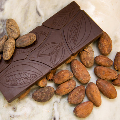 Chocolate bar with cacao beans on a marble surface